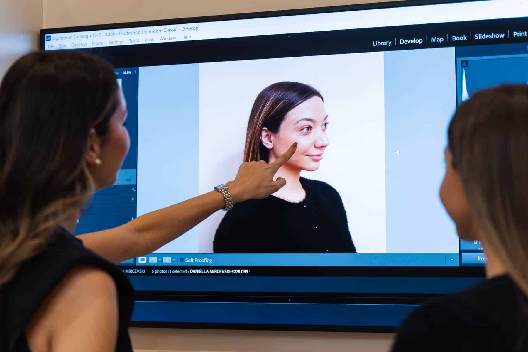 Cosmetic nurse pointing at a screen with an image of patient's face